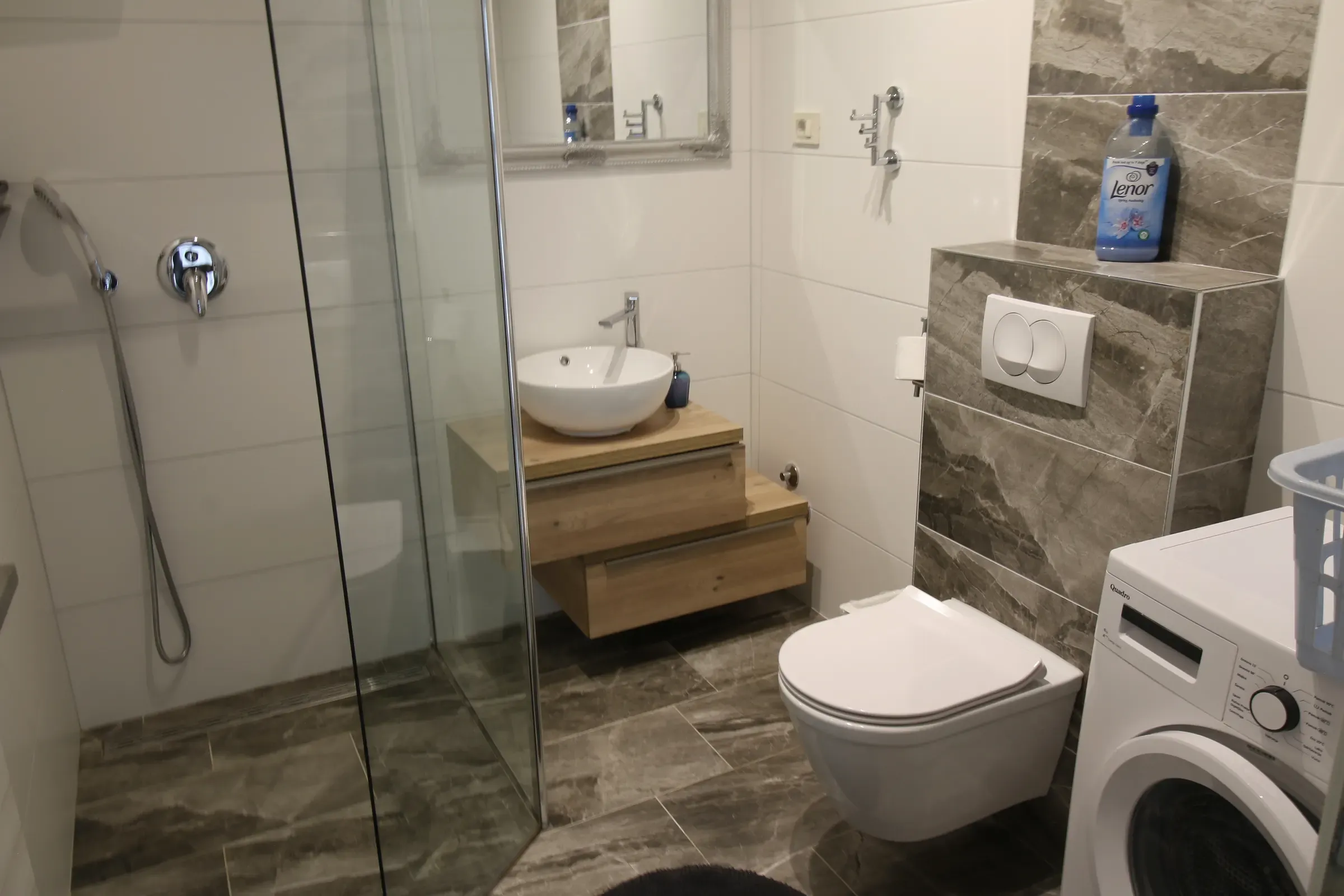 Bathroom with a glass shower and washing machine