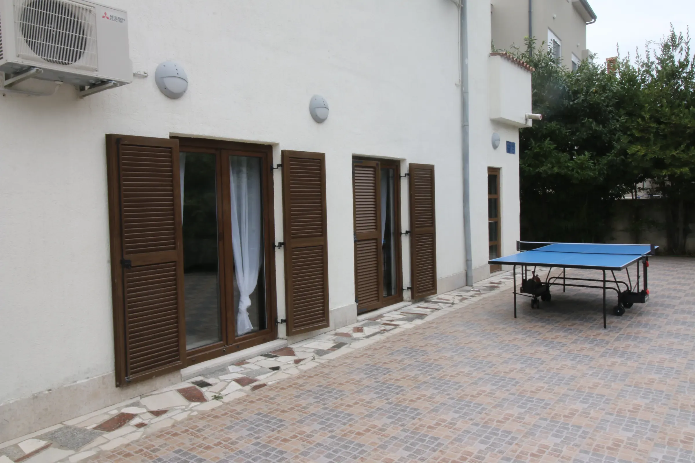 Villa terrace with table tennis beside the shuttered ground floor