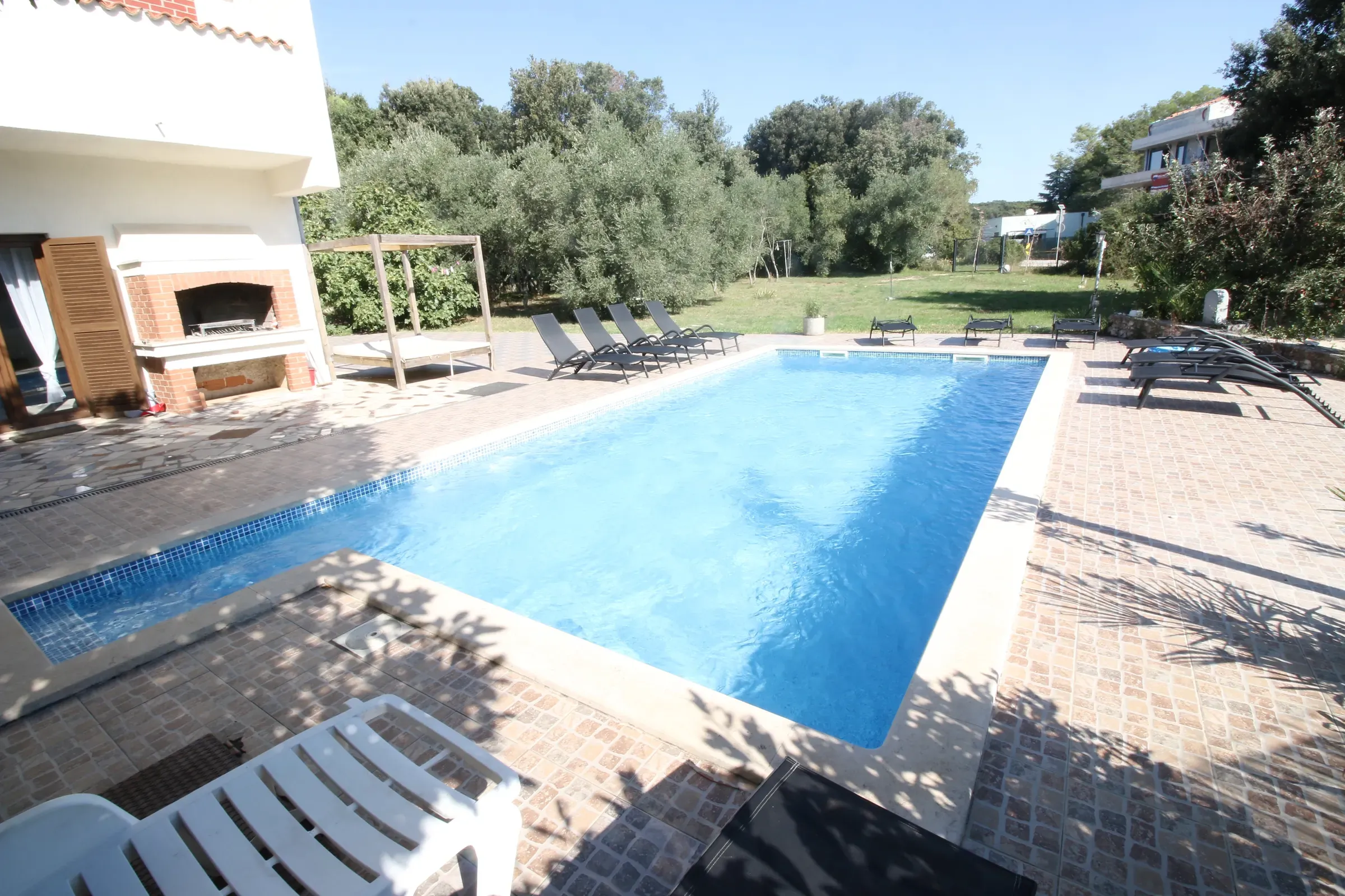 Pool corner with the brick barbecue and covered lounge behind