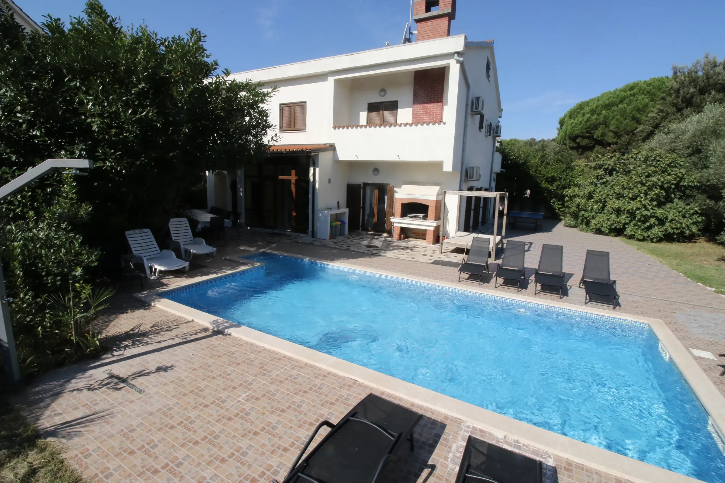 Looking down the private pool toward the facade of Villa Eucalyptus