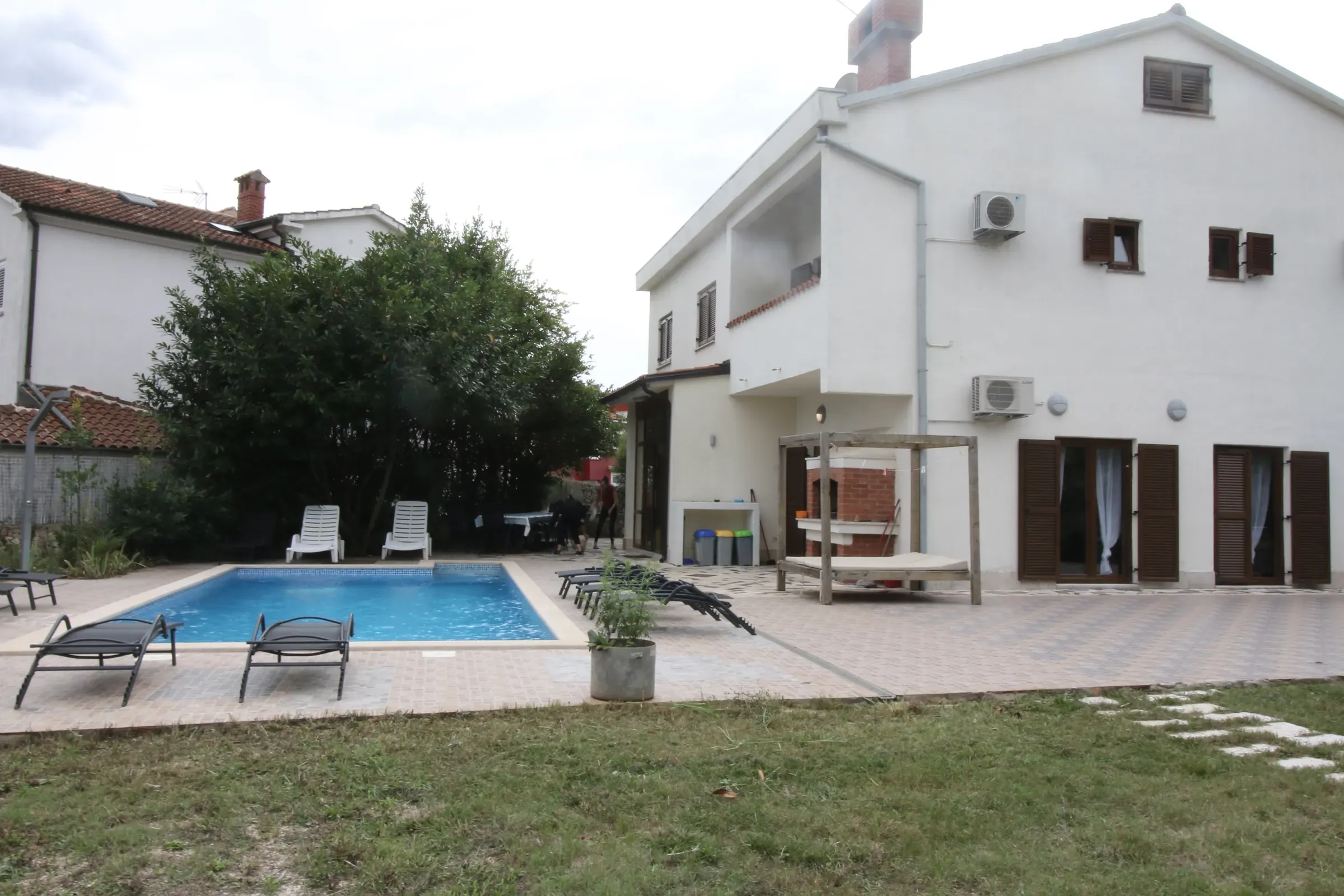 Villa Eucalyptus and its pool seen across the estate lawn