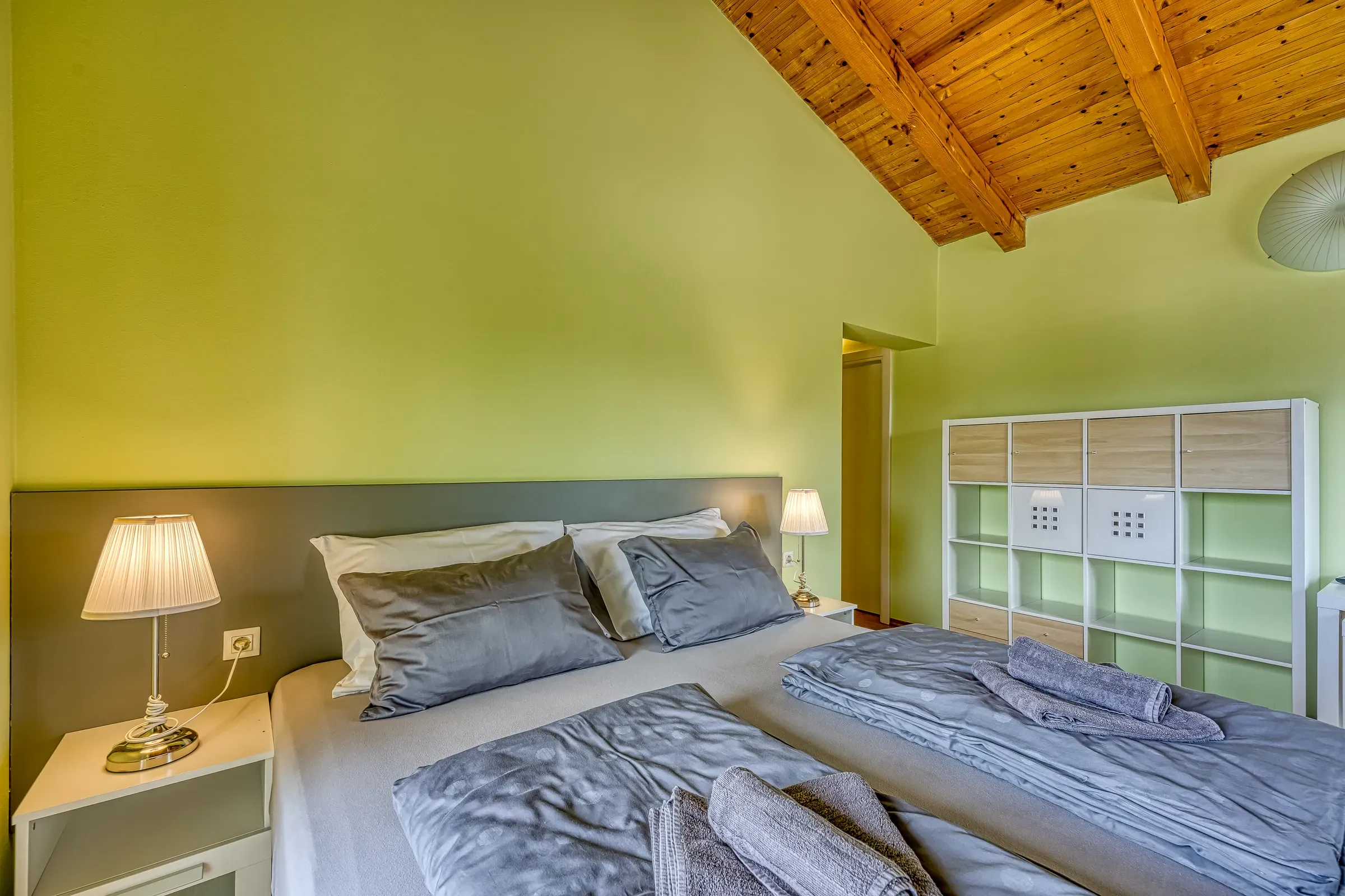 Green double bedroom with bedside lamps and garden light