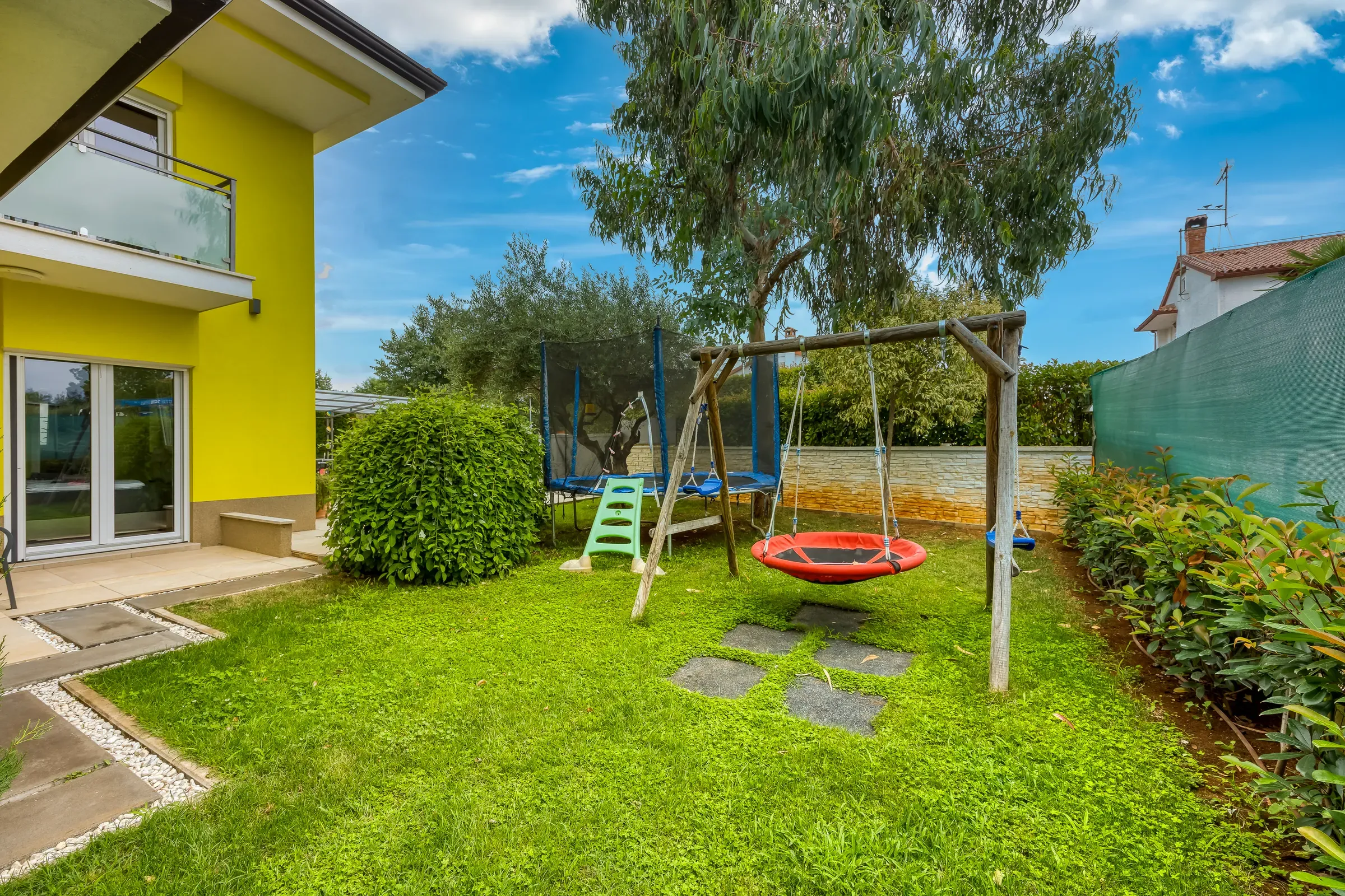 Children’s swings and play corner on the villa lawn