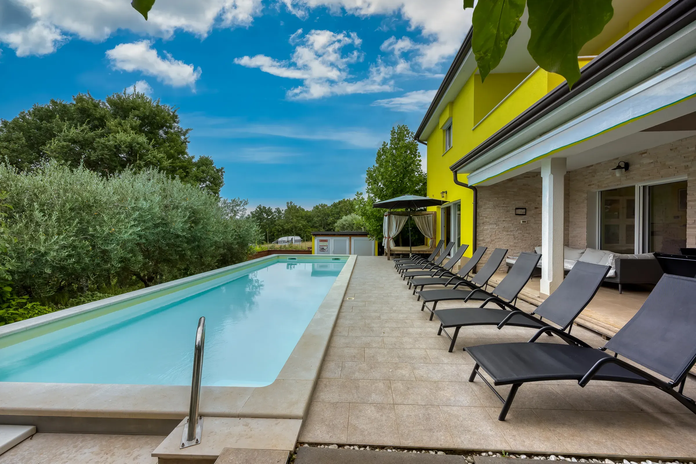 Sun loungers lining the extra-large private pool beside Villa Gaya