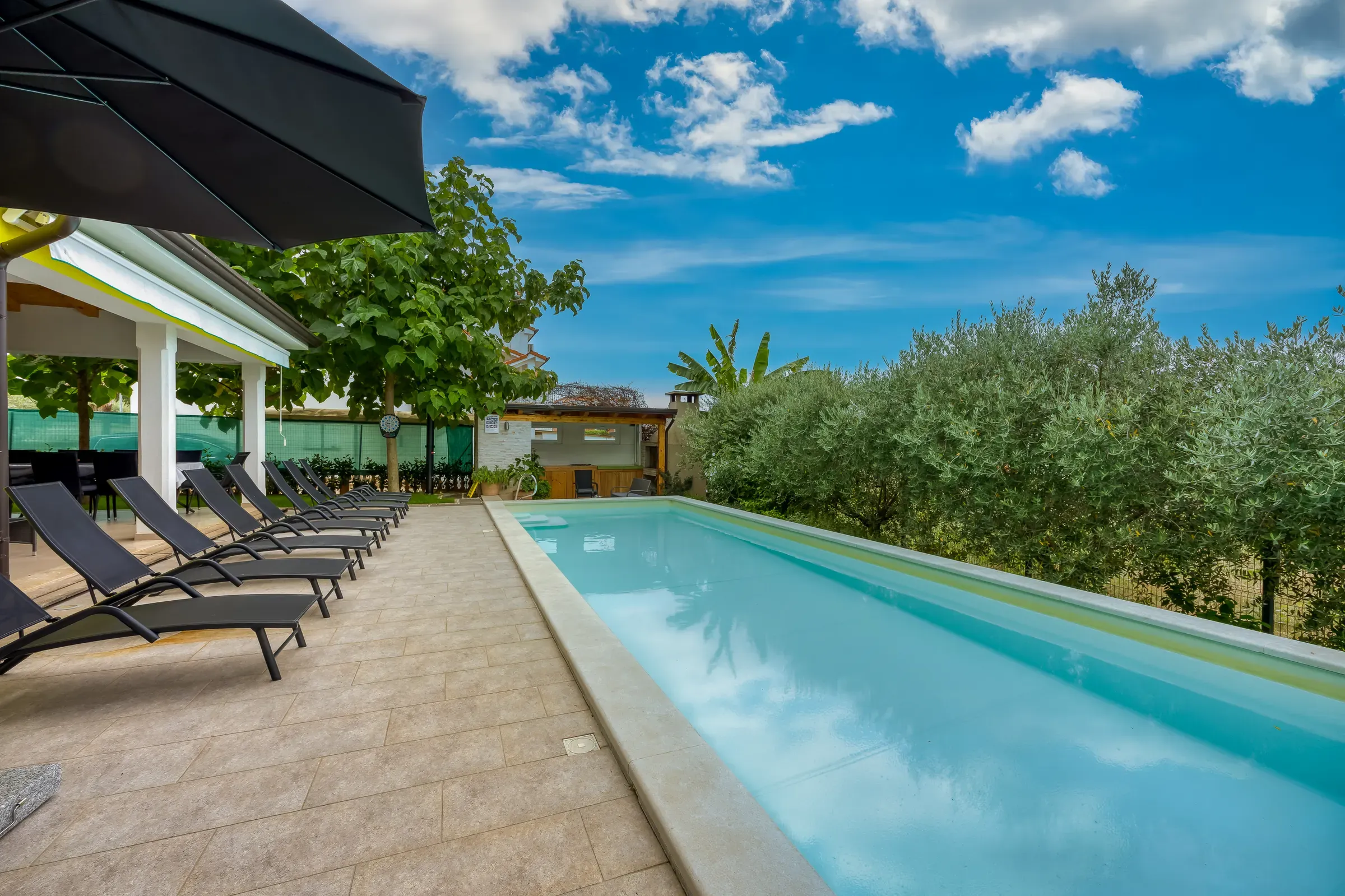 Shaded lounge corner at the head of the long private pool